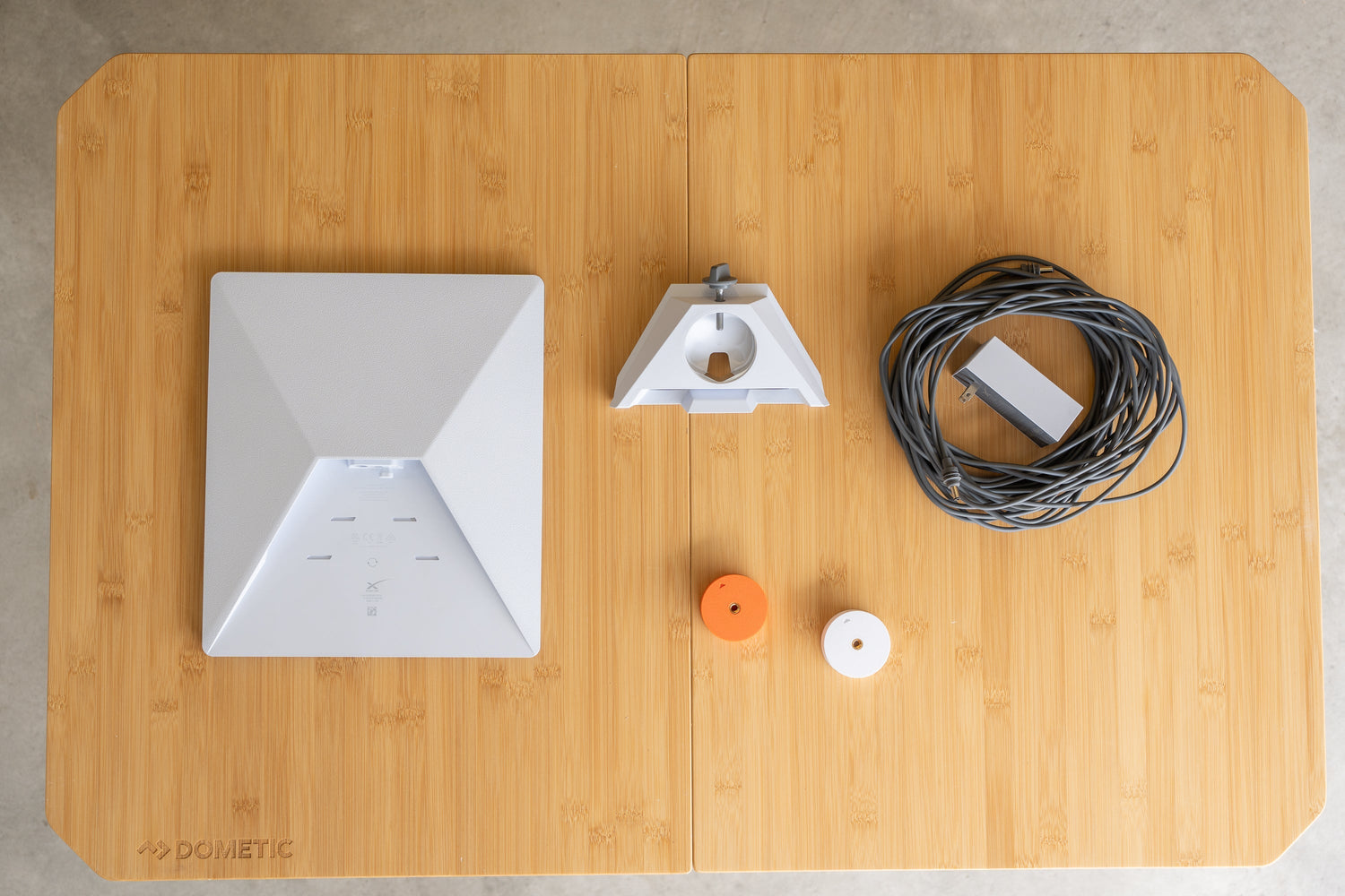 Starlink Mini kit on a table with an orange and white starlink tripod adapter